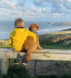 boy with his dog looking at the sea