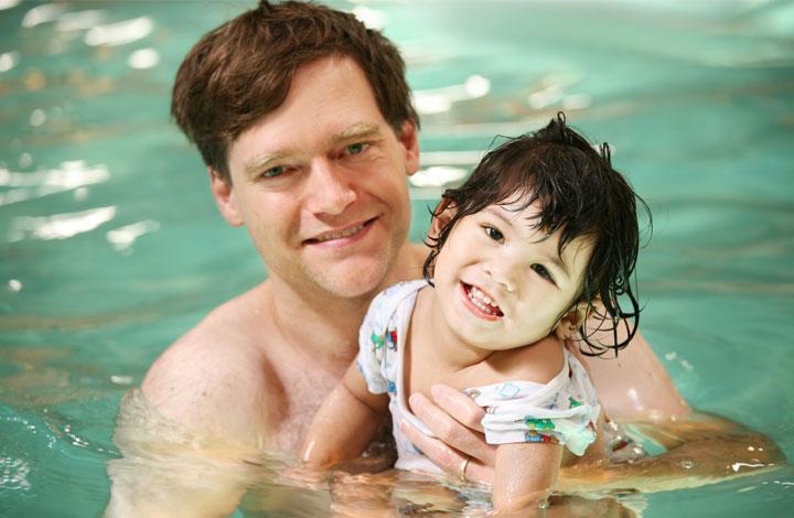 Father and baby girl in swimming pool