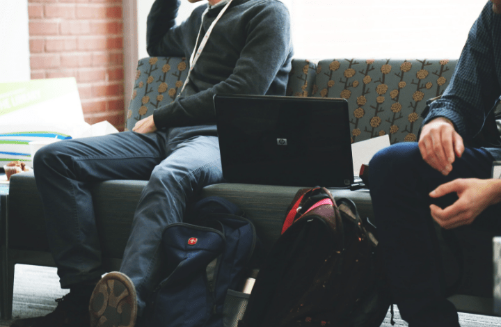 Photo of two students sitting with a laptop beside them