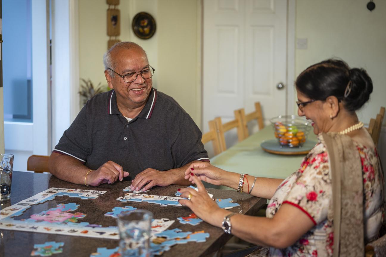 Photo of an older couple doing a jigsaw