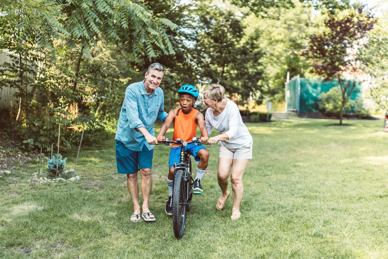 Photo of parents teaching son to ride a bike