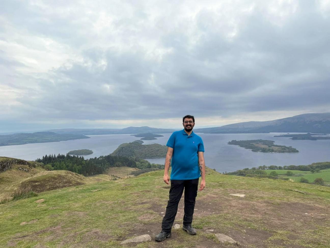A photo of Osama, the writer of this blog, stood outside in nature with lakes in the background