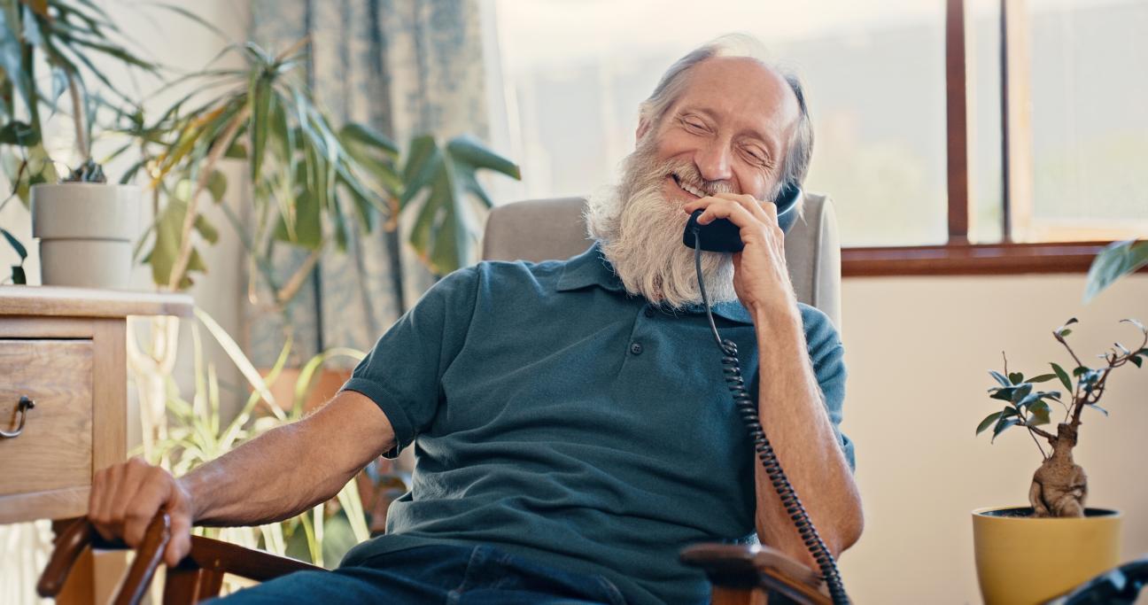 An older man using a corded telephone