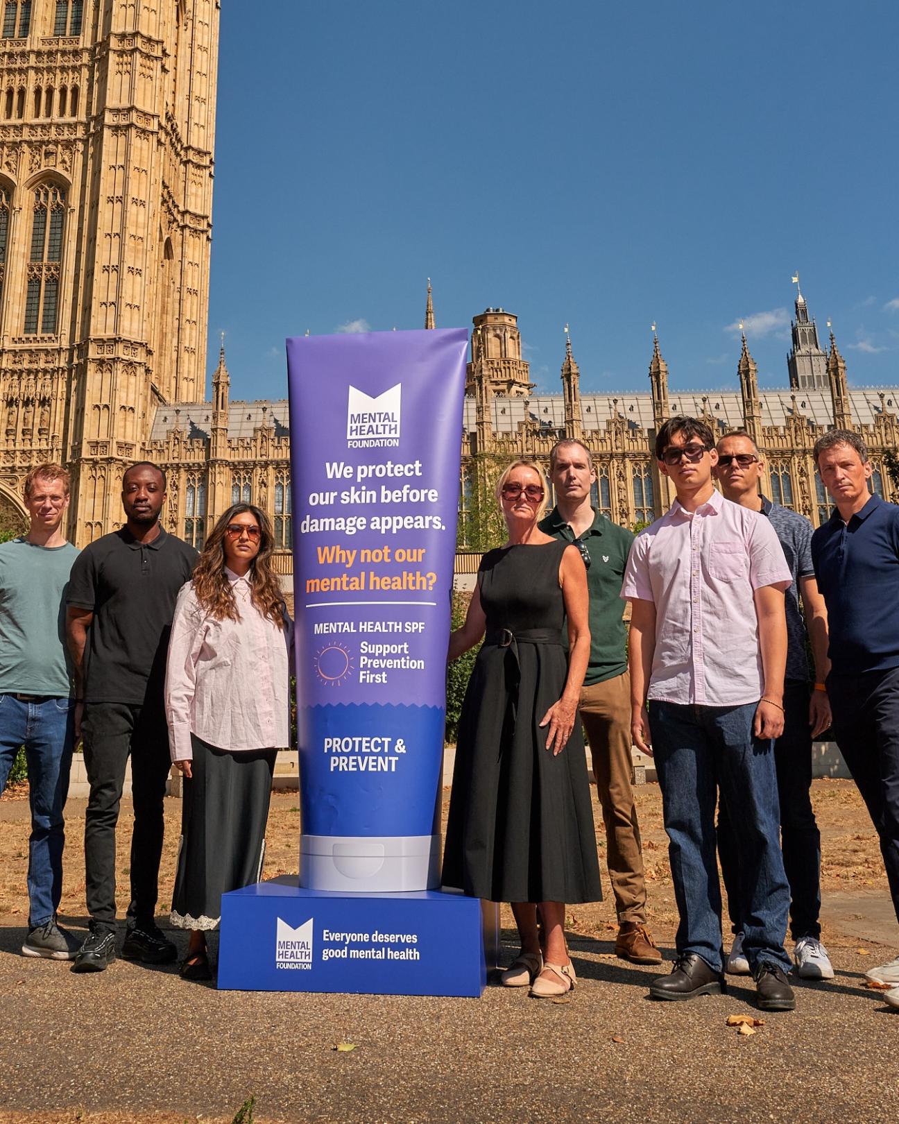 People standing outside Parliament with banner