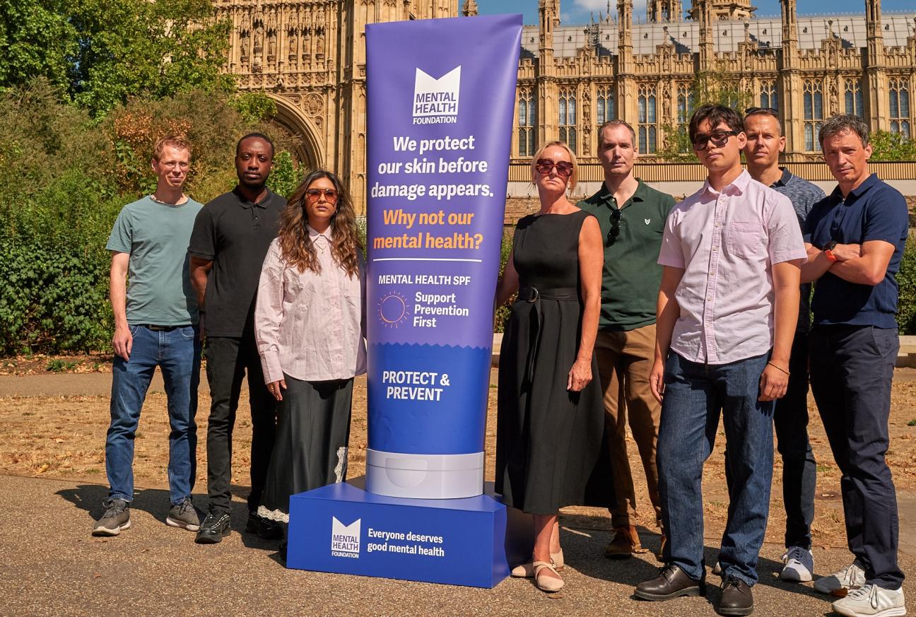 People standing outside Parliament with banner