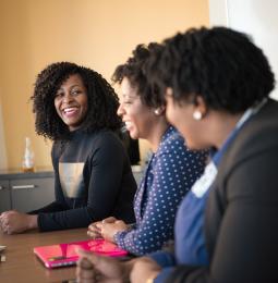 Women in a meeting room smiling