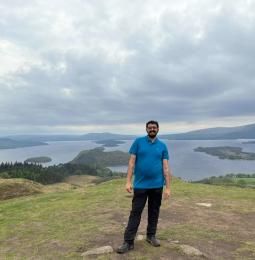 A photo of Osama, the writer of this blog, stood outside in nature with lakes in the background