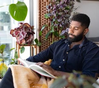 Man reading surrounded by his plants - landscape