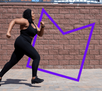 A woman running in front of a brick wall