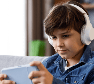 Older child wearing headphones and using a gaming device