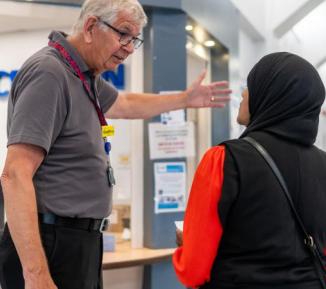 Man giving directions to woman in headscarf