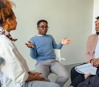 Four people sitting in a circle talking