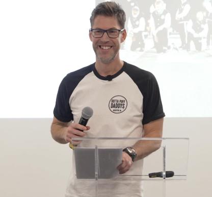 Image of Paul Jukes holding a microphone to give a speech