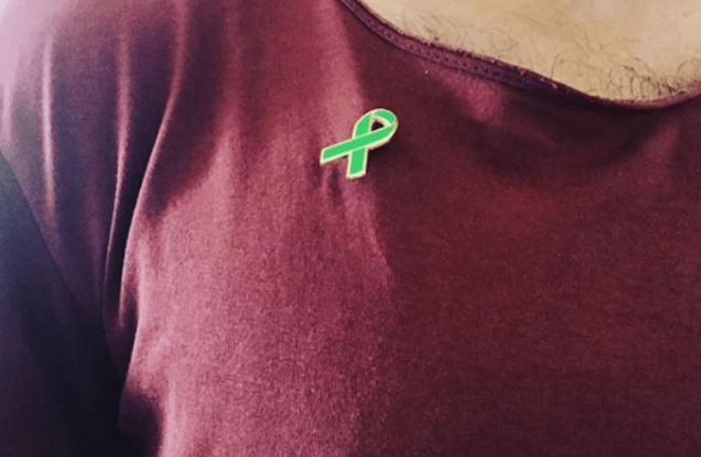 Person wearing green ribbon badge