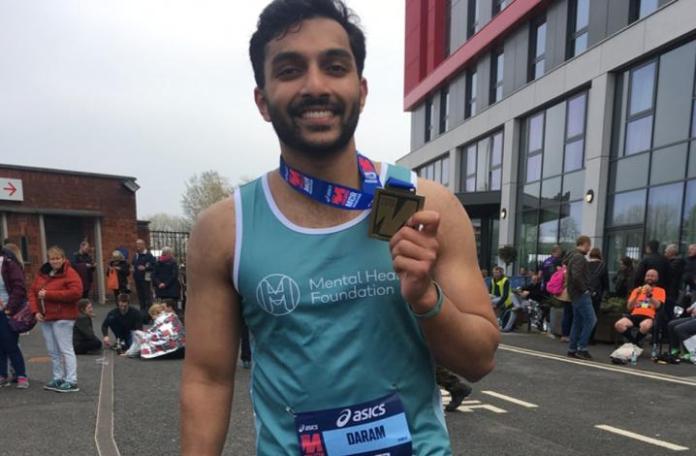 Daram with a medal for running the Manchester Marathon
