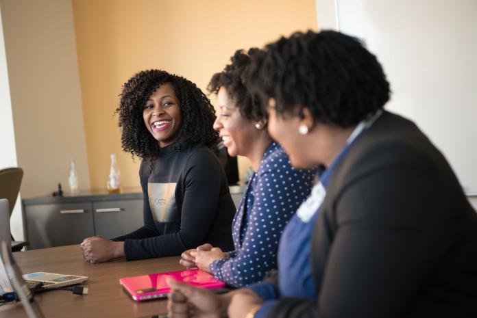 Women in a meeting room smiling