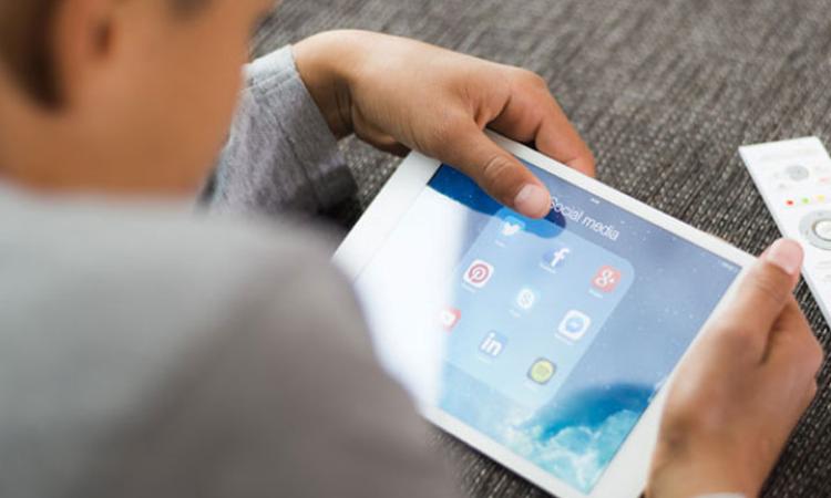 Child with a tablet looking at apps for different social media platforms