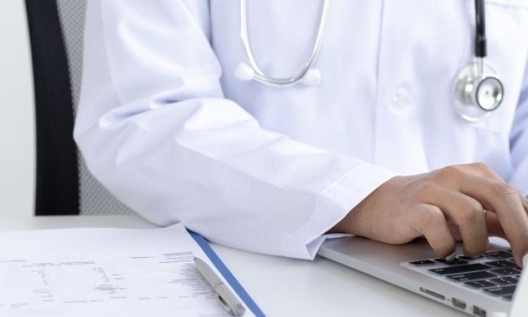 Doctor typing on a laptop