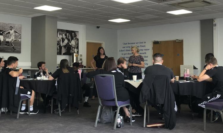 People sitting and talking, whilst the Cardiff City programme is being run