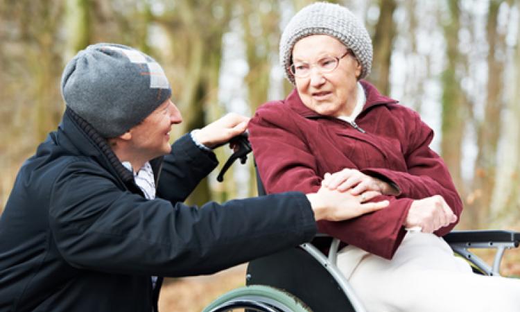 Two people outside, one of which is in a wheelchair