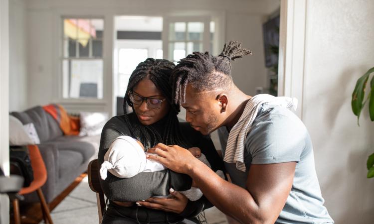 Photo of mother and father holding a young baby