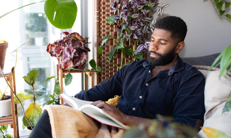 Man reading surrounded by his plants - landscape