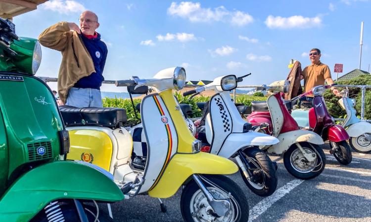 Two men next to vintage motorcycles