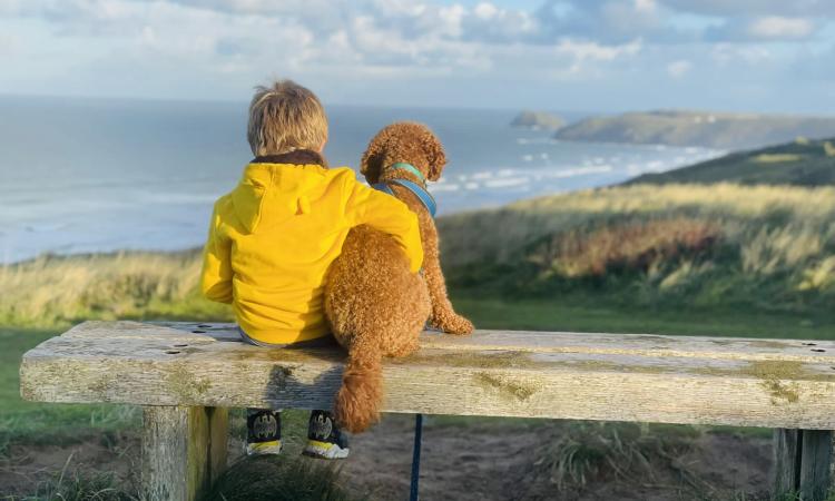 boy with his dog looking at the sea