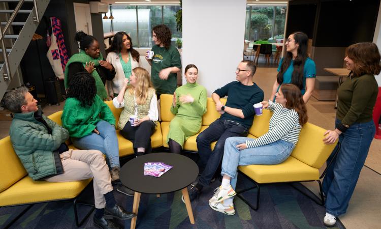 A group of colleagues sitting chatting on a sofa