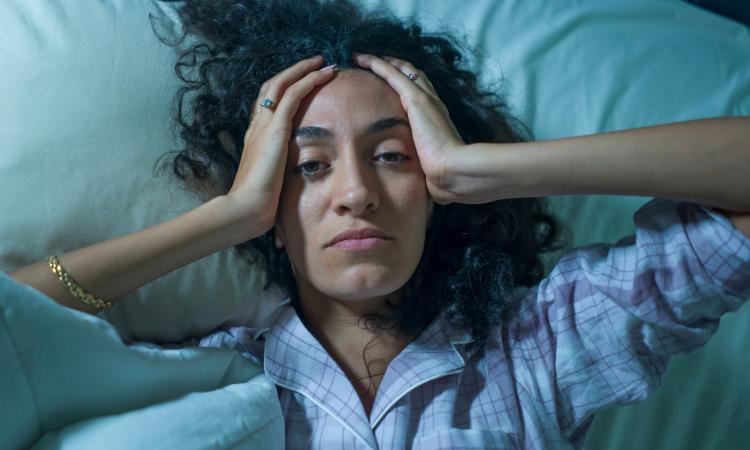 woman in bed feeling anxious