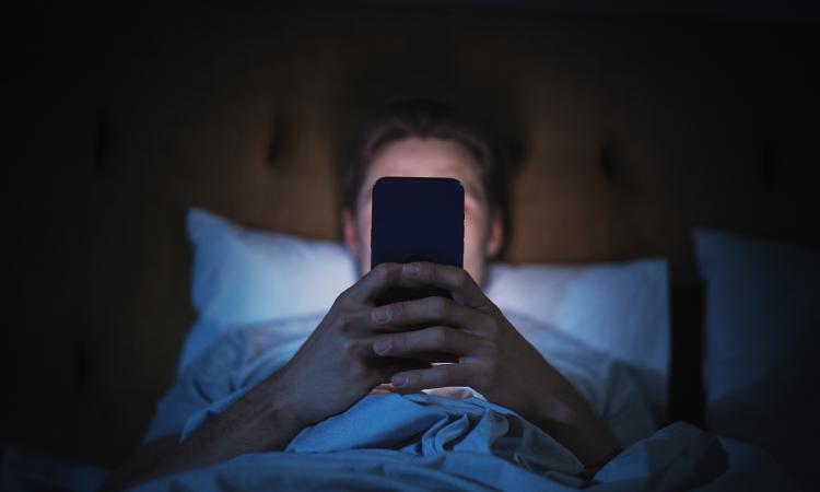 man reading phone in bed 