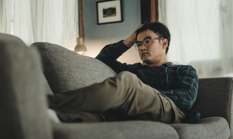 man on sofa feeling anxious