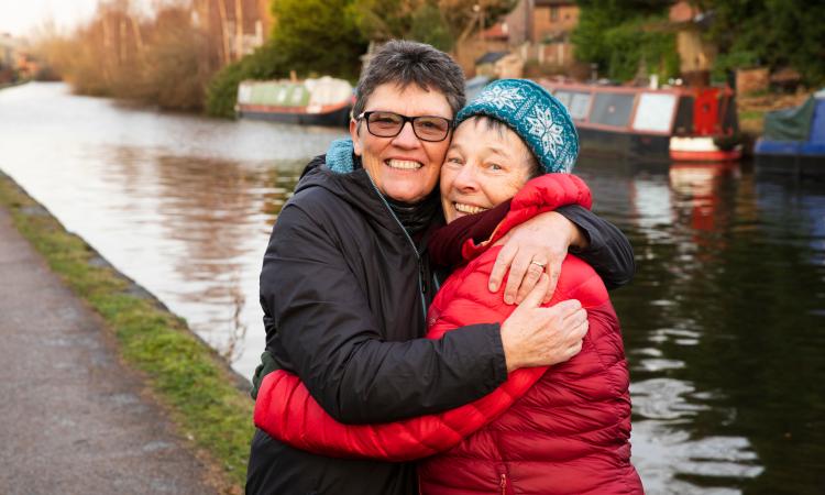 Two women embracing, canal in the background