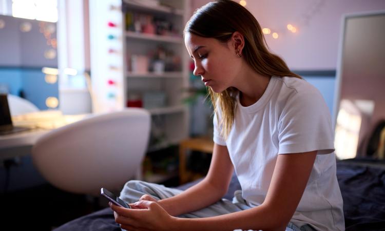 Young person at home scrolling on phone