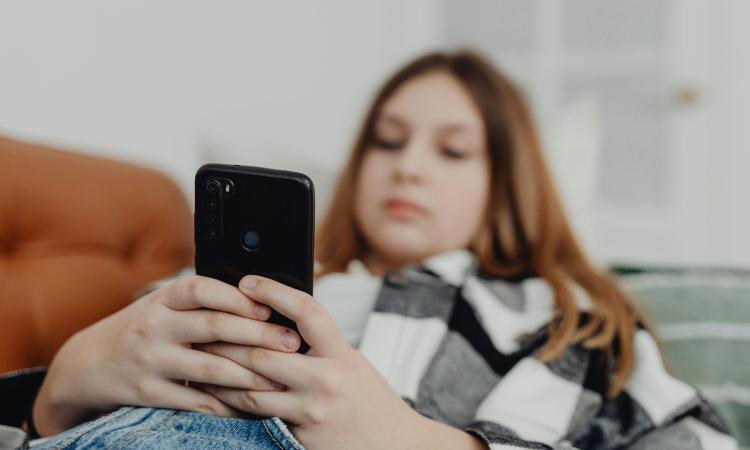 Girl Lying on Sofa and Using Smartphone