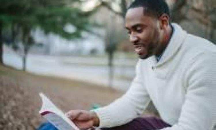 Man reading book outdoors
