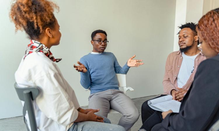 Four people sitting in a circle talking