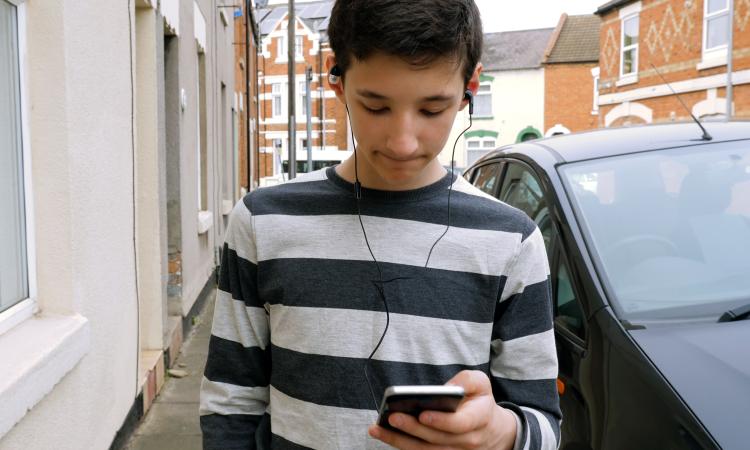 boy with phone alone on street.