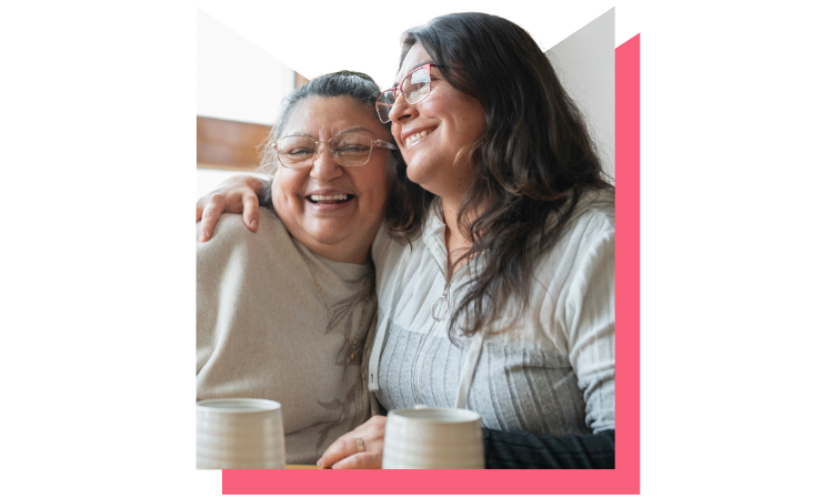 Two women smiling and embracing