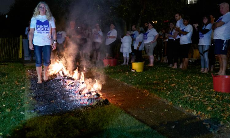 Person completing firewalk in London