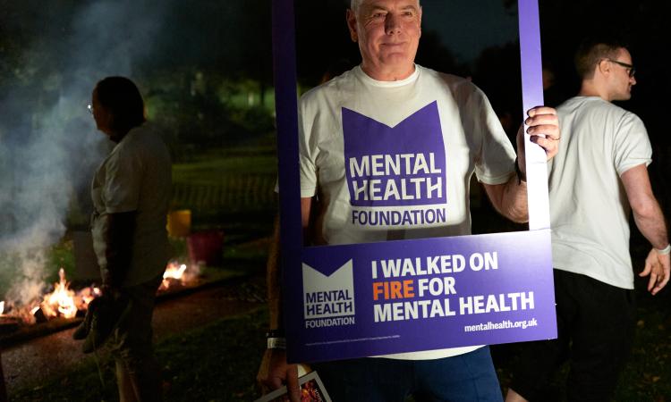 Man holding placard after completing fire walk