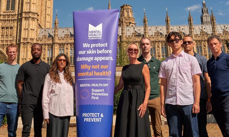 People standing outside Parliament with banner