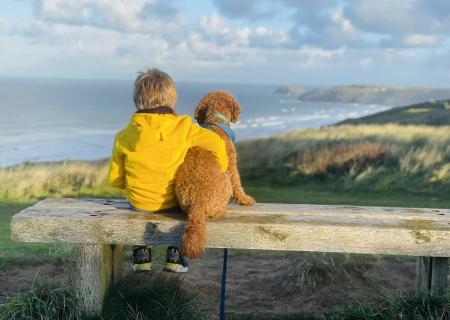 boy with his dog looking at the sea