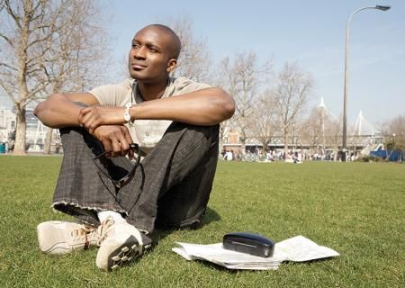 Man sitting on grass in the summer, thinking