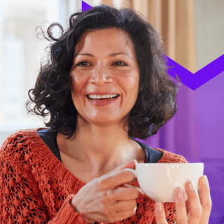 Person holding coffee cup smiling