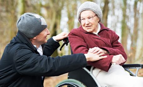 Two people outside, one of which is in a wheelchair