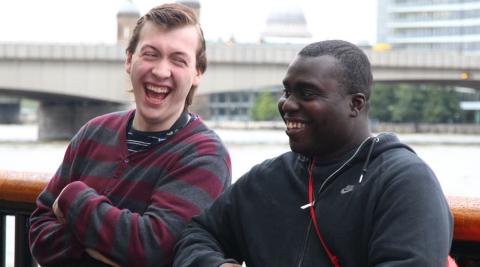 Two men sat outside laughing together