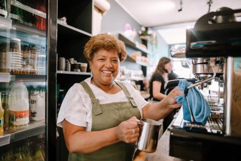 Barista or cafe employee smiling at work