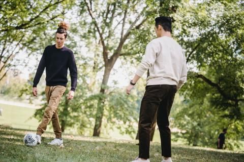Photo of two men playing football and exercising outside