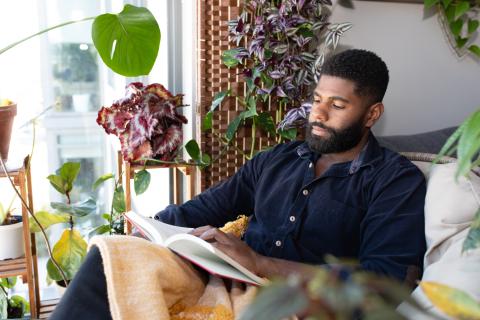 Man reading surrounded by his plants - landscape